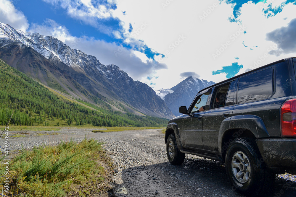 Off-road SUV car with Aktru mountain valley and glacier background. Adventure travel concept. Adventure tourism. Nature landscape. Overland 4x4 journey concept. Off-road SUV car with Aktru mountain valley and glacier background. Adventure travel concept. Adventure tourism. Nature landscape. Overland 4x4 journey concept.