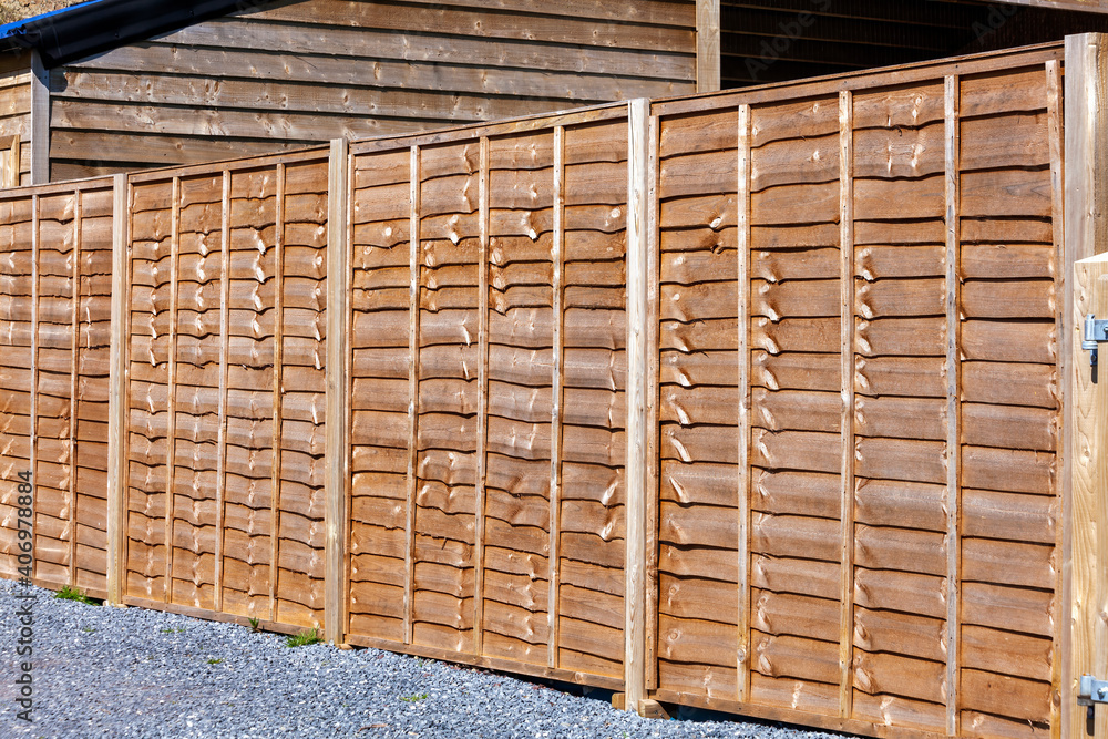 New wooden residential back yard garden fence which is usually made of pine or larch wood, stock photo image