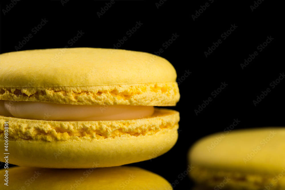 French cookies. Yellow macaroons isolated on a dark, black background. almond cookies. French cookies. Yellow macaroons isolated on a dark, black background. almond cookies.