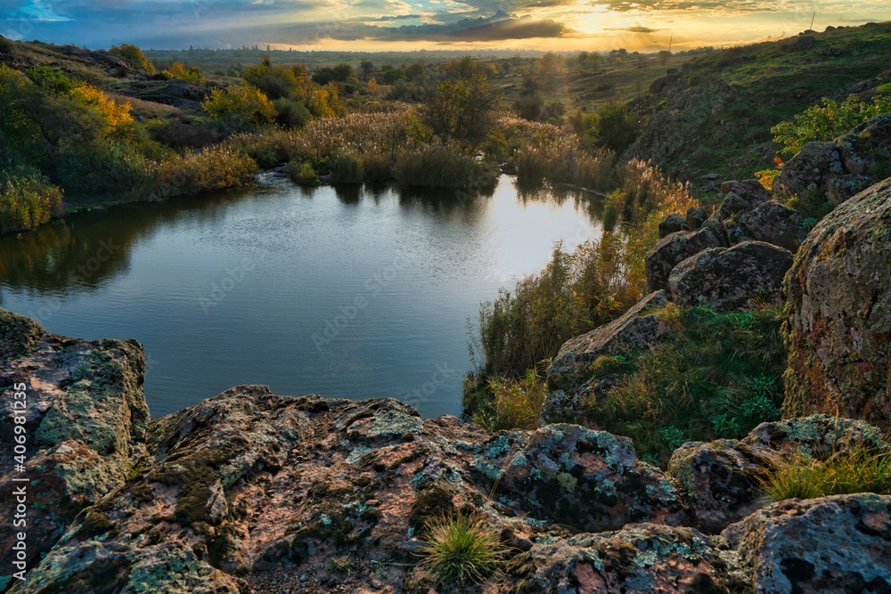 Beautiful small river among large stones and green vegetation on the hills in Ukraine