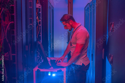 Man in dark server room with blue backlight
