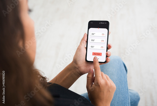 Unrecognizable Lady Buying Tickets Using Smartphone Application Sitting Indoors