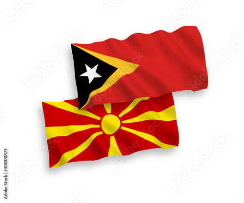 National vector fabric wave flags of East Timor and North Macedonia isolated on white background. 1 to 2 proportion.