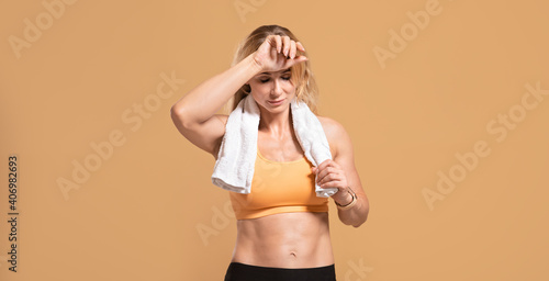Sport, catch breath and rest. Tired muscular mature woman in sportswear