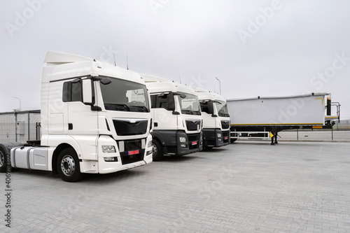 Parked trucks and trailers in a parking lot. New car park, Freight transport by road, Logistics and transport