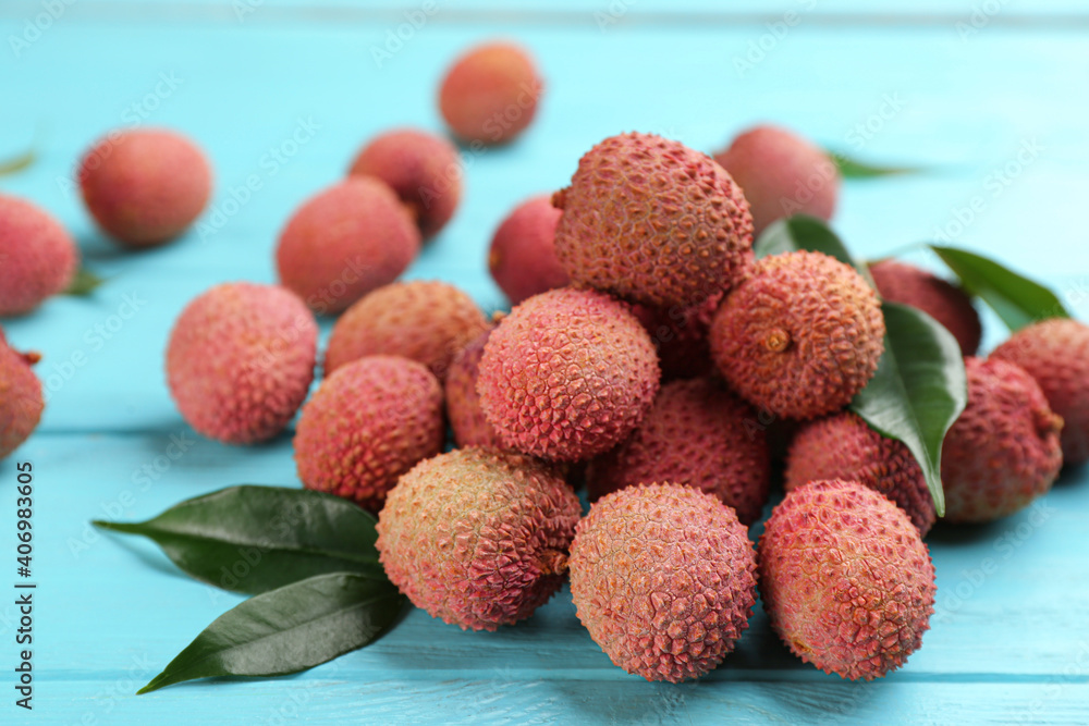 Fresh ripe lychee fruits on light blue wooden table Fresh ripe lychee fruits on light blue wooden table
