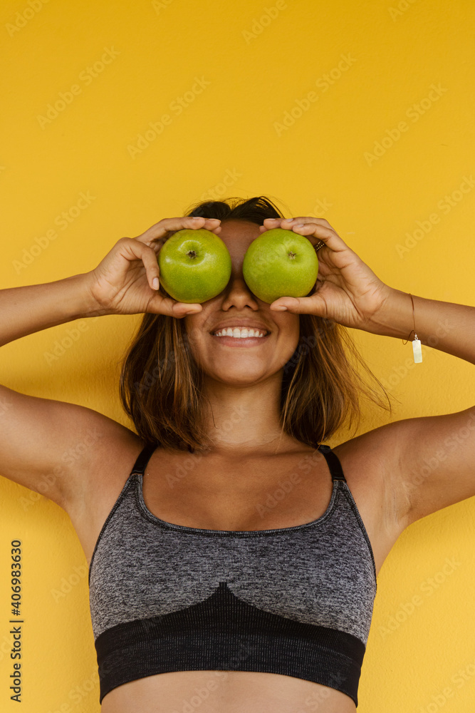 healthy, smiling woman putting the apples in her eyes on a yellow background Health, diet, eating, slimming healthy, smiling woman putting the apples in her eyes on a yellow background Health, diet, eating, slimming