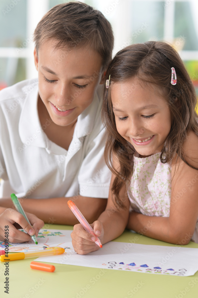Smiling brother and sister drawing together Smiling brother and sister drawing together