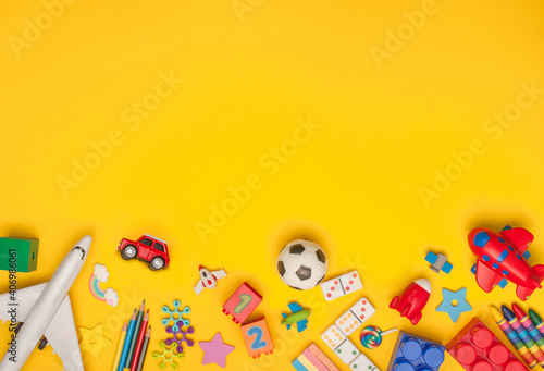 Frame of kids toys on yellow background with copyspace photo