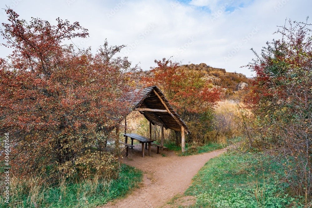 Small wooden gazebo among beautiful autumn trees on the Carpathian hills in Ukraine