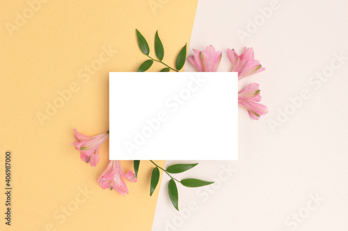 Fototapeta Naklejka Na Ścianę i Meble -  Floral frame made of alstroemeria flower on a beige and gold background. Empty paper card mockup. Springtime concept for 8 March or Mothers Day.