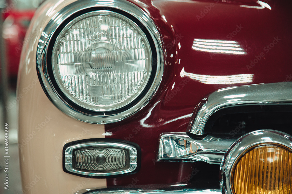 headlights of a retro vintage car in red in a showroom.