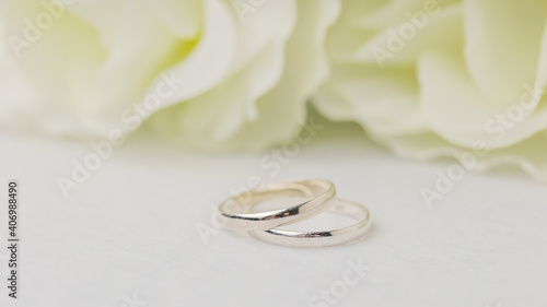 Wedding rings lie near a beautiful bouquet as bridal accessories.Wedding rings and roses bouquet.concept for a wedding card.