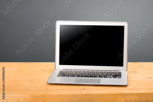 Laptop with blank screen for product display in office with modern blurred background