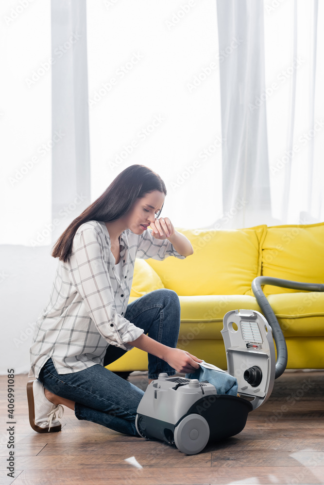 allergic woman wiping nose while changing dust bag in vacuum cleaner Stock  Photo | Adobe Stock