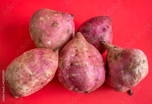 sweet potatoes isolated on red background.
