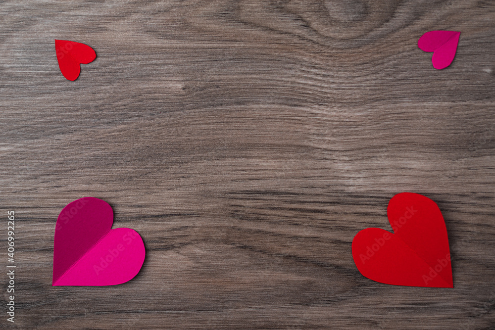 Fototapeta premium Cutted and folded paper Red hearts on a dark wooden Background. Card for Valentine's Day. with space for text.