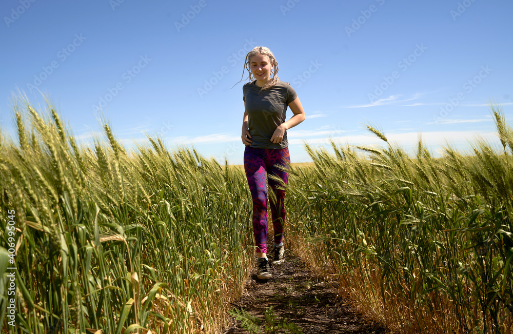 Running In The Wheat. Young teen girl running through wheat field in late summer Running In The Wheat. Young teen girl running through wheat field in late summer