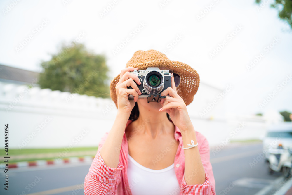 Beautiful tourist women with camera take photo while travel in Bangkok city