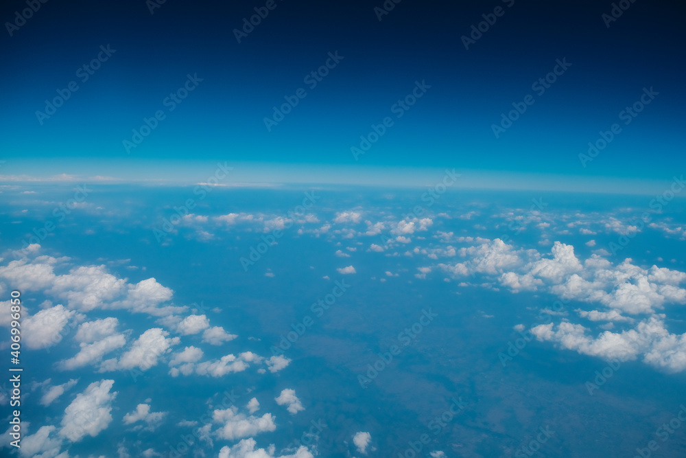 Blue sky background with tiny clouds from airplane