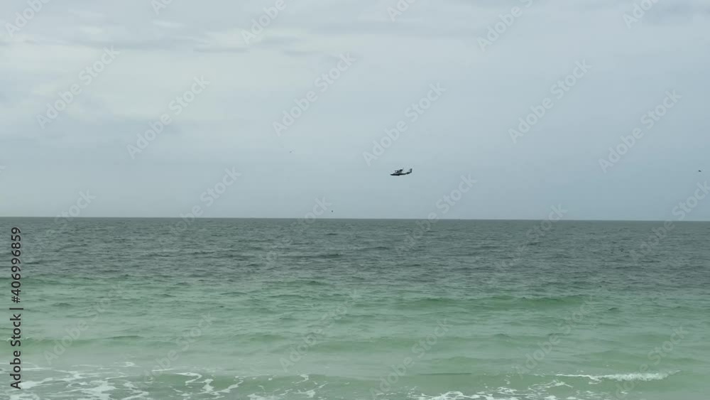 Three small sea planes flying over the ocean near the shore. Three small sea planes flying over the ocean near the shore.