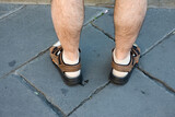 An Englishman abroad: sandals with socks on a pair of not so stylish legs in the Piazza della Signoria, Florence, Tuscany, Italy