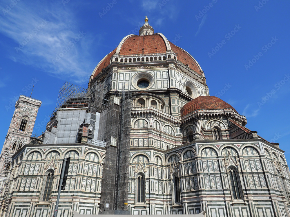Florence Cathedral of Saint Mary of the Flower, colored marble facade with red tiled Dome, Brunelleschi cupola and elegant Campanile, Giotto bell tower. Famous UNESCO Complex in the Piazza del Duomo.