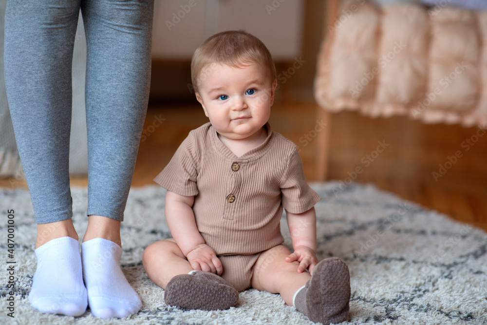 Fototapeta premium Cute little baby sitting on floor at home