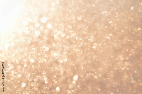 Glitter abstract background with unfocused soft golden light. Defocused image.