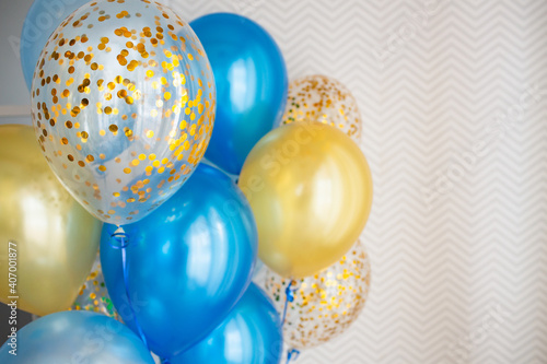 Blue and transparent balloons with golden confetti on zigzag wallpaper background