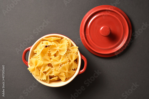 Directly above to Cooking pan with cover filled with raw italian farfale pasta on isolated on dark background 
 photo