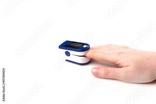 Close up of Finger and hand in an Oximeter Device. Pulse oximeter on white background.