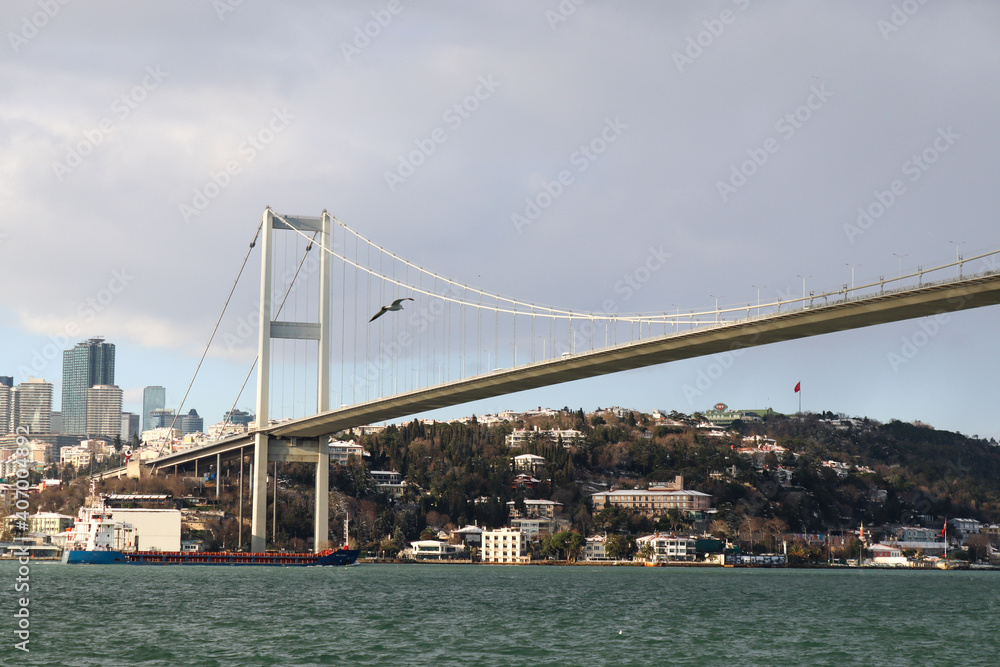 Naklejka premium The Bosphorus Bridge, thus connecting Europe and Asia (alongside Fatih Sultan Mehmet Bridge and Yavuz Sultan Selim Bridge). The bridge extends between Ortaköy (in Europe) and Beylerbeyi (in Asia).