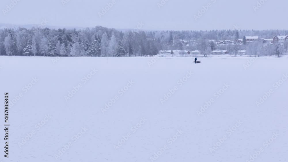 one person on a sled on frozen lake one person on a sled on frozen lake