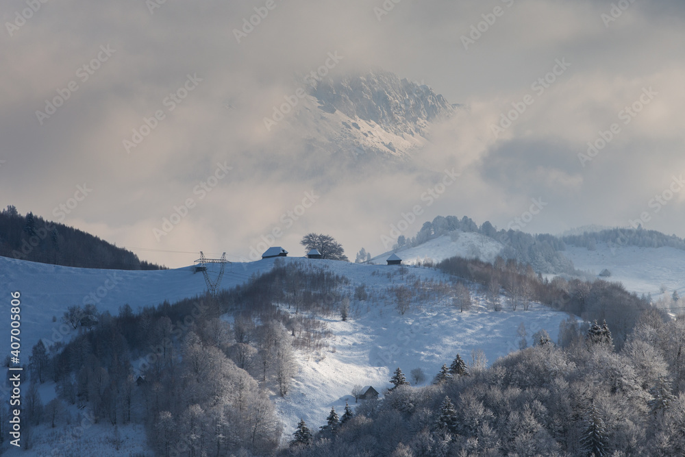 Winter frosty landscape of the beautiful Transylvanian village, Bran, with fresh snow, at the foot of the Carpathian Mountains