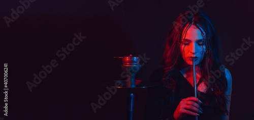 A young girl enjoys smoking a hookah, sheesha. Photo with space for text