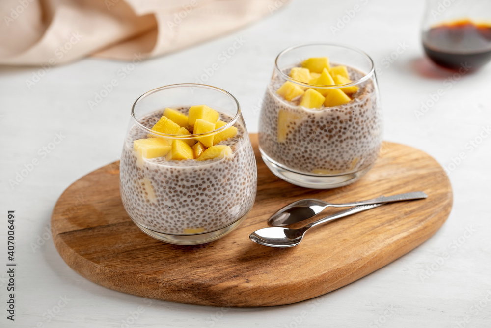 Vegan chia coconut pudding with mango on white background. Healthy nutrition, superfood. Closeup view. Vegan chia coconut pudding with mango on white background. Healthy nutrition, superfood. Closeup view.