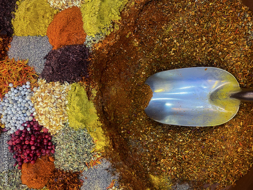 A metal spoon with spices. Multi-colored spices and salt. Background.