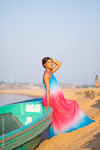 portrait of a beautiful young african woman posing on a boat on the shore of a river