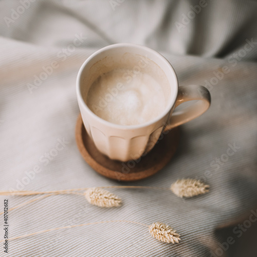 Cup of coffee with milk on beige plaid. Flat lay  top view still life morning breakfast. Comfort  cosiness and warmth concept. Photo in light pastel colors