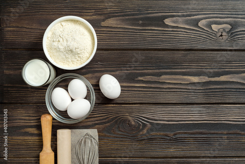 composition with ingredients for making dough on a dark wood background with copy space.