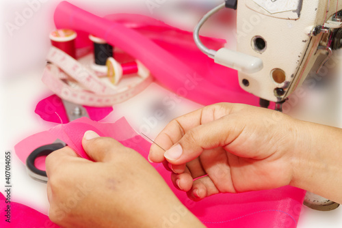 Asian woman sewing on the desk in the studio. photo