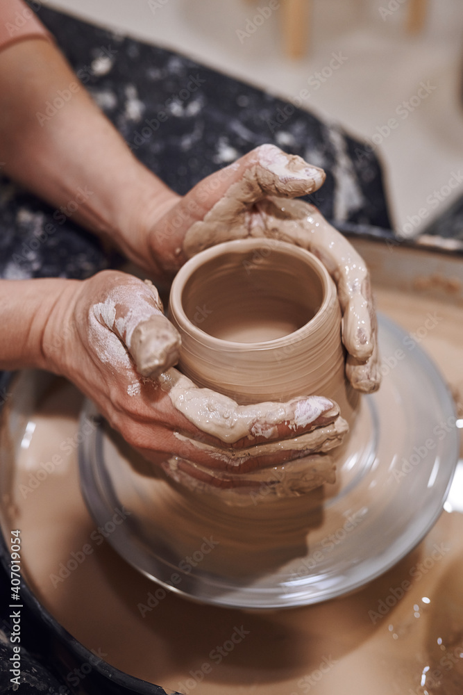Women working on potters wheel making clay objects in pottery workshop Women working on potters wheel making clay objects in pottery workshop