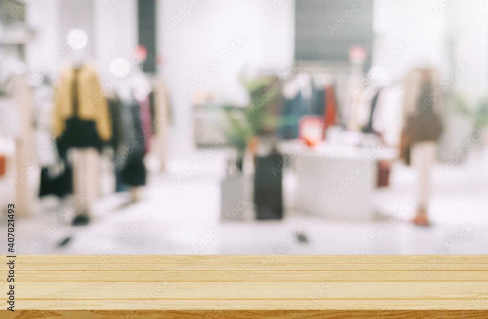 Empty brown wooden table and De focused/blurry background of clothing store with bokeh image luxury and fashionable brand for display or montage your products Empty brown wooden table and De focused/blurry background of clothing store with bokeh image luxury and fashionable brand for display or montage your products