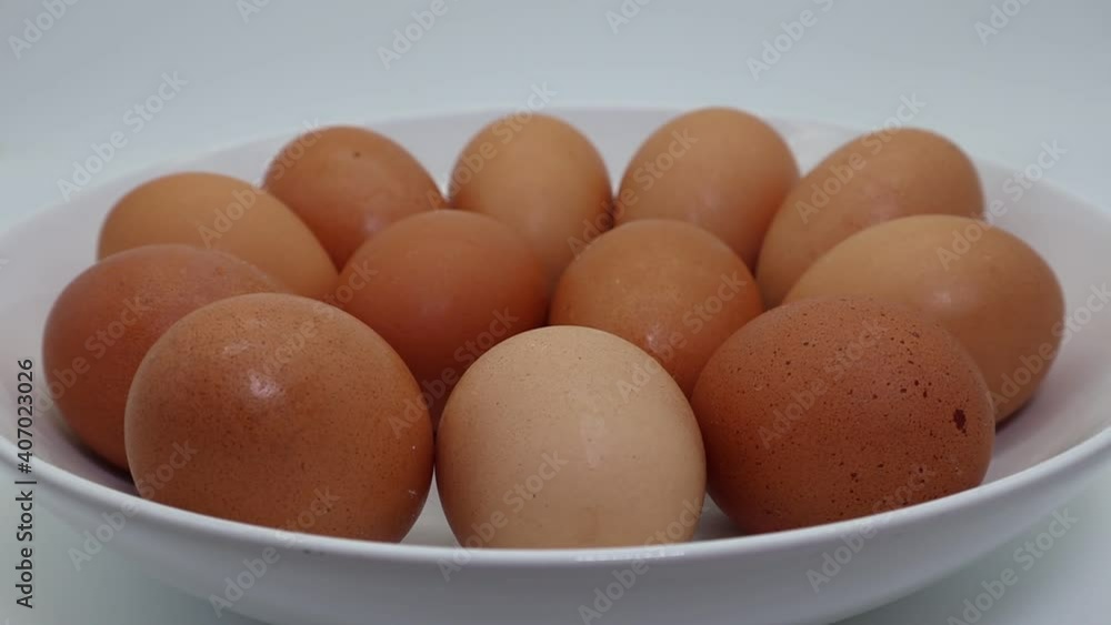 Fresh eggs in a dish on rotating display isolated on white background Fresh eggs in a dish on rotating display isolated on white background