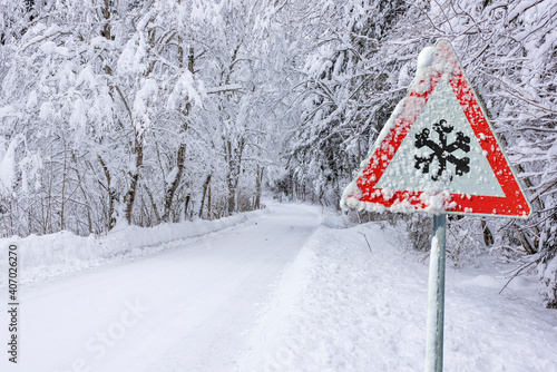 road sign warns of ice and snow at winter