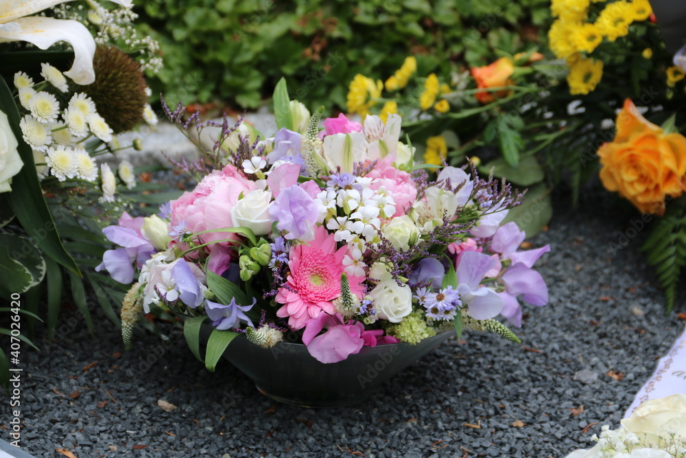 Bunte Blumen schmücken ein Grab nach Beerdigung