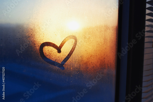 Heart drawn on a misty window photo