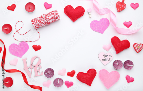 Hearts with ribbons and candles on white background