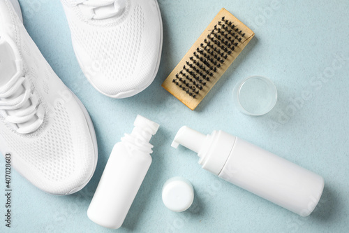 Flat lay composition with stylish footwear and shoe care accessories on light background